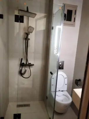 a bathroom with a toilet and a glass shower stall at Luxury Apartment Agdal, Ideal for CAN 2025 Fans in Rabat