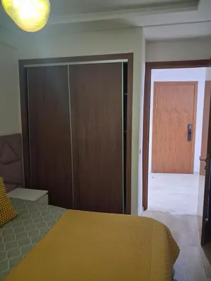 a bedroom with a bed and a sliding door at Moderne Studio En plein quartier Maârif avec wifi, balcon,parking et trés bon emplacement in Casablanca