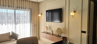 a living room with a couch and a tv and a window at Zenata Luxury Stay in Aïn Harrouda