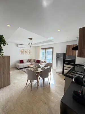 a kitchen and living room with a table and chairs at VIVASTAY Casablanca - Zenata eco city beach access with swimming pool in Aïn Harrouda