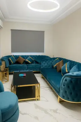 a living room with a blue couch and a table at Najia Blue Pearl in Sidi Rahal