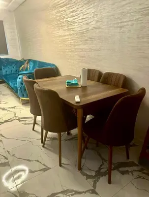 a table and chairs in a living room with a couch at Najia Blue Pearl in Sidi Rahal