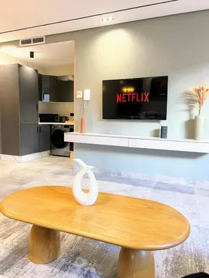 a wooden table in a living room with a tv at Appartement CFC in Casablanca