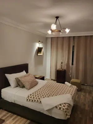 a bedroom with a large bed and a chandelier at Appartement chic de 3 chambres au cœur de Casablanca in Casablanca
