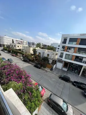 a city street with cars parked in front of a building at Appartement confortable in Maarif