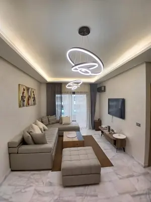 a living room with a couch and a tv at Cozy 2-bedroom apartment, pool view with beach access a Zenata City Eco Casablanca in Oulad Akkou