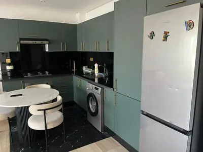 a kitchen with green cabinets and a white refrigerator at Studio Les princesses in Maarif