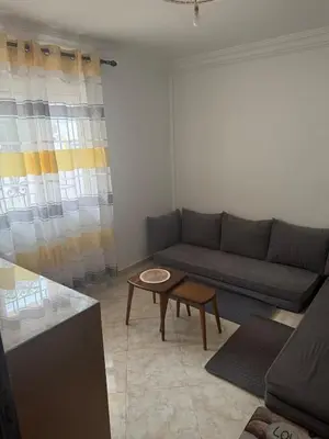 a living room with a couch and a table at relaxing apartment in Bouznika in Bouznika