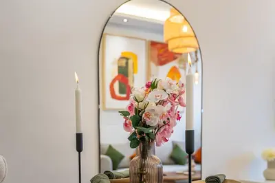a vase of flowers on a table in front of a mirror at Luxury Studio Apartment - Maarif Near CFC & Downtown in Casablanca