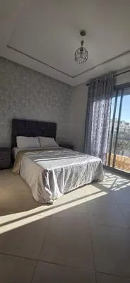 a bedroom with a bed and a large window at luxury apartment DT2 in Mohammedia