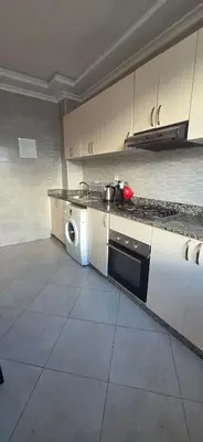 a kitchen with a stove and a washing machine at luxury apartment DT2 in Mohammedia
