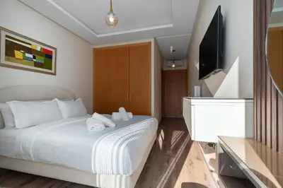 a bedroom with a bed and a flat screen tv at Luxury 2BR Pearl of Agdal Near Agdal Train Station in Rabat