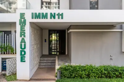 a building with a sign that reads imini nishi at Luxury 2BR Pearl of Agdal Near Agdal Train Station in Rabat