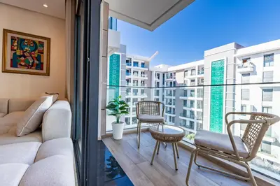 a living room with a couch and chairs on a balcony at Luxury 2BR Pearl of Agdal Near Agdal Train Station in Rabat