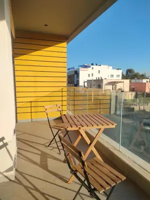 a wooden table and chairs on a balcony with a view at Studio haut standing in Casablanca