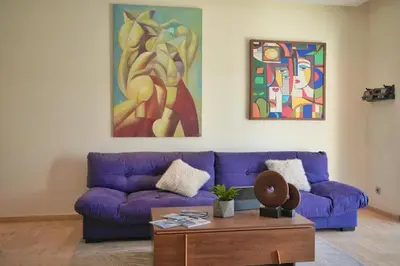 a living room with a purple couch and a table at Casablanca Finance City 2Bdr in Casablanca