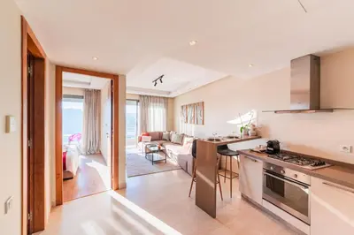 a kitchen and living room with a view of the ocean at Urban Escape Designer Apartment with Balcony in Casablanca