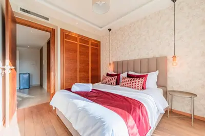 a bedroom with a large bed with red and white pillows at Urban Escape Designer Apartment with Balcony in Casablanca