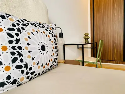 a bedroom with a bed with a pillow and a chair at Welcome Stay Centre Casa Gares &Tram in Casablanca