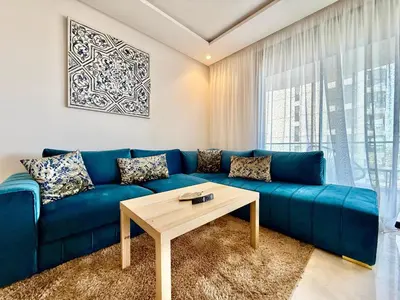 a blue couch in a living room with a table at Beau studio a CFC in Casablanca