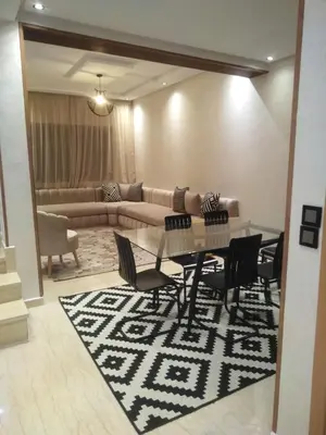 a living room with a table and chairs and a couch at Beautiful apartment in Hay Al Qods Bernoussi in Casablanca