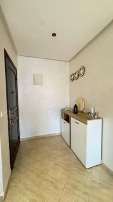 a room with a kitchen with a counter and a door at Appartement meublé à HARHOURA in Temara