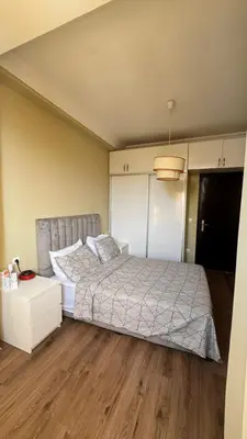 a bedroom with a bed and a wooden floor at Appartement meublé à HARHOURA in Temara