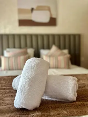 a pile of towels sitting on top of a bed at Charming Studio in Zenata Eco-city, Pool and Sea View in Aïn Harrouda