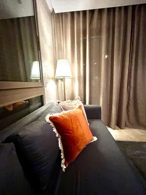 a bedroom with a bed with an orange pillow at Charming Studio in Zenata Eco-city, Pool and Sea View in Aïn Harrouda