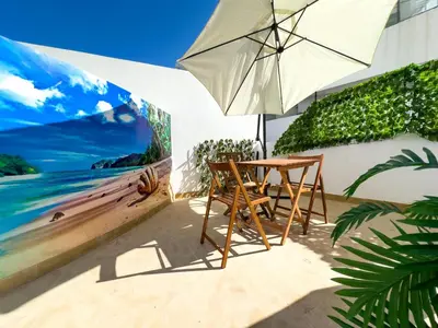 a table and chairs and an umbrella on the beach at Modern, Fully Equipped Studio Just Steps from Mohammed 5 Stadium, Maarif in Casablanca