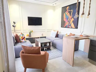 a living room with a couch and a tv at Casablanca METROPOL Suites in Casablanca