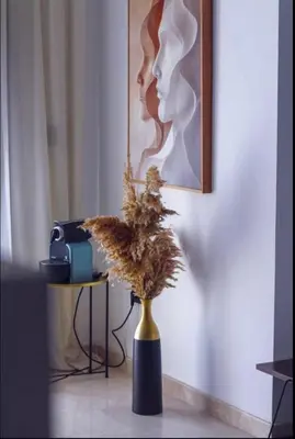 a vase with a plant in front of a painting at Sleek Modern Studio with Plenty of Light in Casablanca