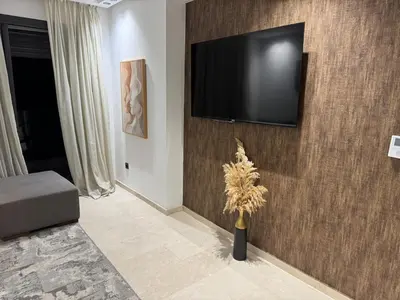 a living room with a television on a wall at Sleek Modern Studio with Plenty of Light in Casablanca