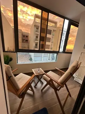 a living room with two chairs and a table at High standing 2 bedroom apartment in Casablanca