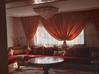 a living room with a red couch and a window at Villa avec piscine proche de la mer in Mohammedia