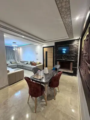 a living room with a table and chairs and a couch at Résidence Macha'allah in O Ben Slimane