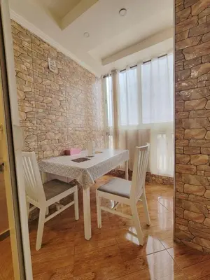 a table and chairs in a room with a stone wall at 7 min to beach luxury apartment Dar Bouazza in Casablanca