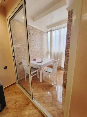 a dining room with a table and chairs and a glass wall at 7 min to beach luxury apartment Dar Bouazza in Casablanca