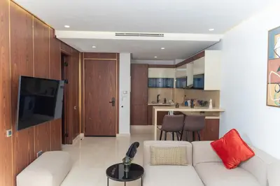 a living room with a white couch and a kitchen at Peaceful Haven for a Quiet Stay in Maarif 500m to Mohamed Stadium in Casablanca