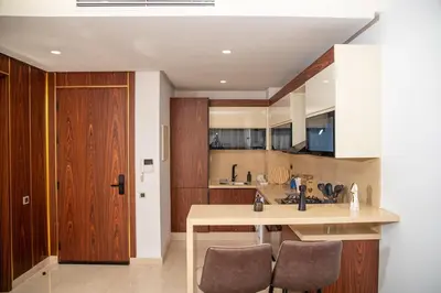 a kitchen with a sink and a counter with chairs at Peaceful Haven for a Quiet Stay in Maarif 500m to Mohamed Stadium in Casablanca