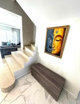 a painting of a face on a wall with a bench at Villa Sophia in Dar Bouazza