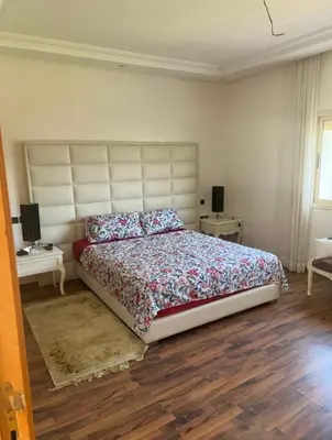 a bedroom with a large bed and a wooden floor at seaside entire villa with pool view in Casablanca
