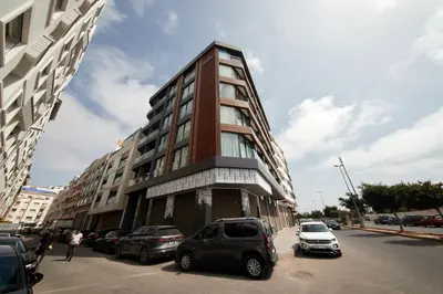 a tall building with cars parked in front of it at Marilla Studio - Elegant & Peaceful Stay in Bourgogne, Steps from Mohamed V Stadium in Casablanca