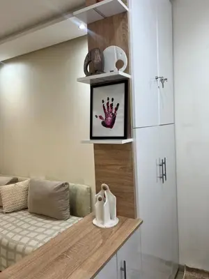 a room with a bed and a shelf with a crown on it at Modern Comfort Studio, la corniche in Mohammedia