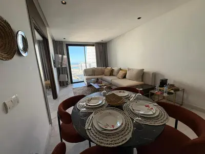 a living room with a table and a couch at Cosy Studio at B-Living Casa Port Ideal for Business & City Trips with Open View Heart Of Casablanca in Casablanca