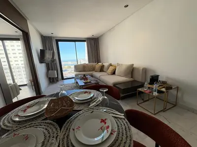 a living room with a table and a couch at Cosy Studio at B-Living Casa Port Ideal for Business & City Trips with Open View Heart Of Casablanca in Casablanca