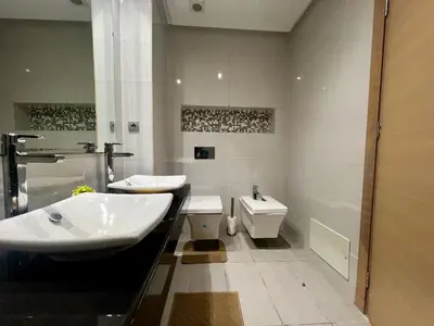 a white bathroom with a sink and a toilet at Urban Chic 2BR - Prestigia near stadium in Rabat