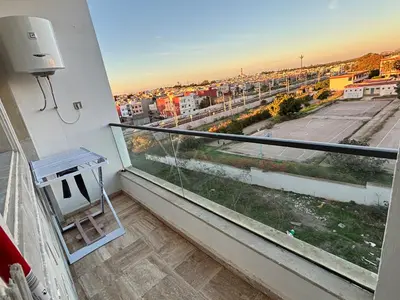 a balcony with a view of a tennis court at Appartement moderne aux perles de temara in Temara