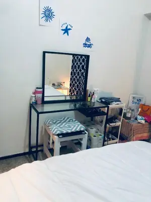 a bedroom with a bed and a desk with a mirror at Chambre cosy vue sur jardin in Mohammedia