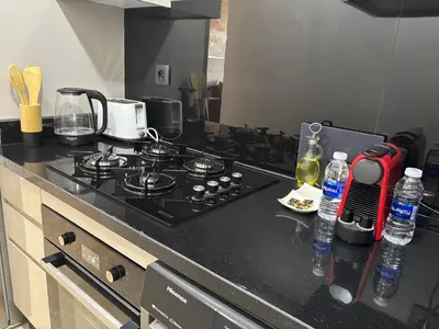 a kitchen counter with a stove and bottles of water at Studio moderne avec Fibre Optique, 55po TV et CVC in Casablanca